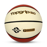 Close-up of the NIVIA Top Grip 3.0 Basketball match ball with a textured cream and red surface, black channel lines, and printed branding, indicating compound rubber construction with official size and weight for indoor and outdoor play.