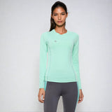 Front view of a woman wearing the NIVIA Hydra 12 Active Long Sleeve T-Shirt in mint green, featuring a round neckline and full sleeves, paired with grey athletic leggings for fitness and training use.