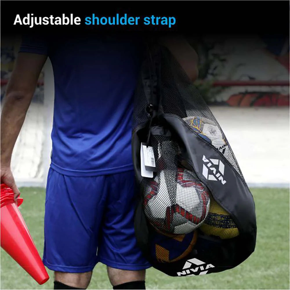 Person wearing a blue sports outfit carrying a black NIVIA Ball Carrying Bag with an adjustable shoulder strap, filled with multiple sports balls, highlighting the bag’s comfortable over-the-shoulder design for easy transport on the field.