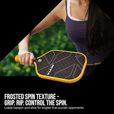A lifestyle promotional image showing a person's hand holding a NIVIA pickleball paddle with a yellow grip and edge guard. The paddle face features a black carbon checkered pattern with white geometric lines. The background is a soft-focus green outdoor setting. Bold white text at the bottom reads: FROSTED SPIN TEXTURE - GRIP. RIP. CONTROL THE SPIN. Loads topspin and slice for angles that punish opponents.