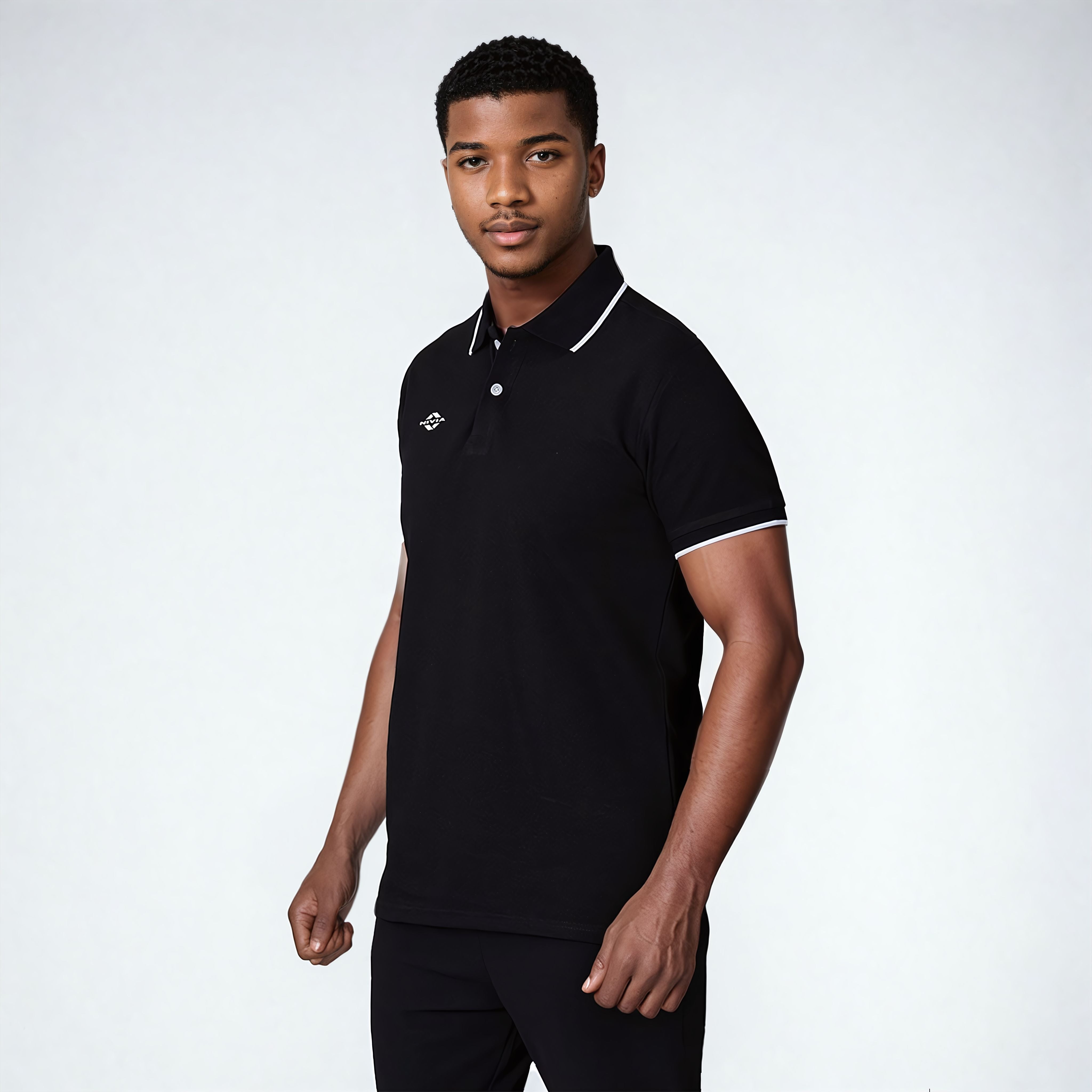 Model wearing the NIVIA Ray 17 Polo Shirt in black, featuring a classic collar with button placket and contrast trim on the collar and sleeve cuffs, made from polyester cotton fabric for everyday casual wear.