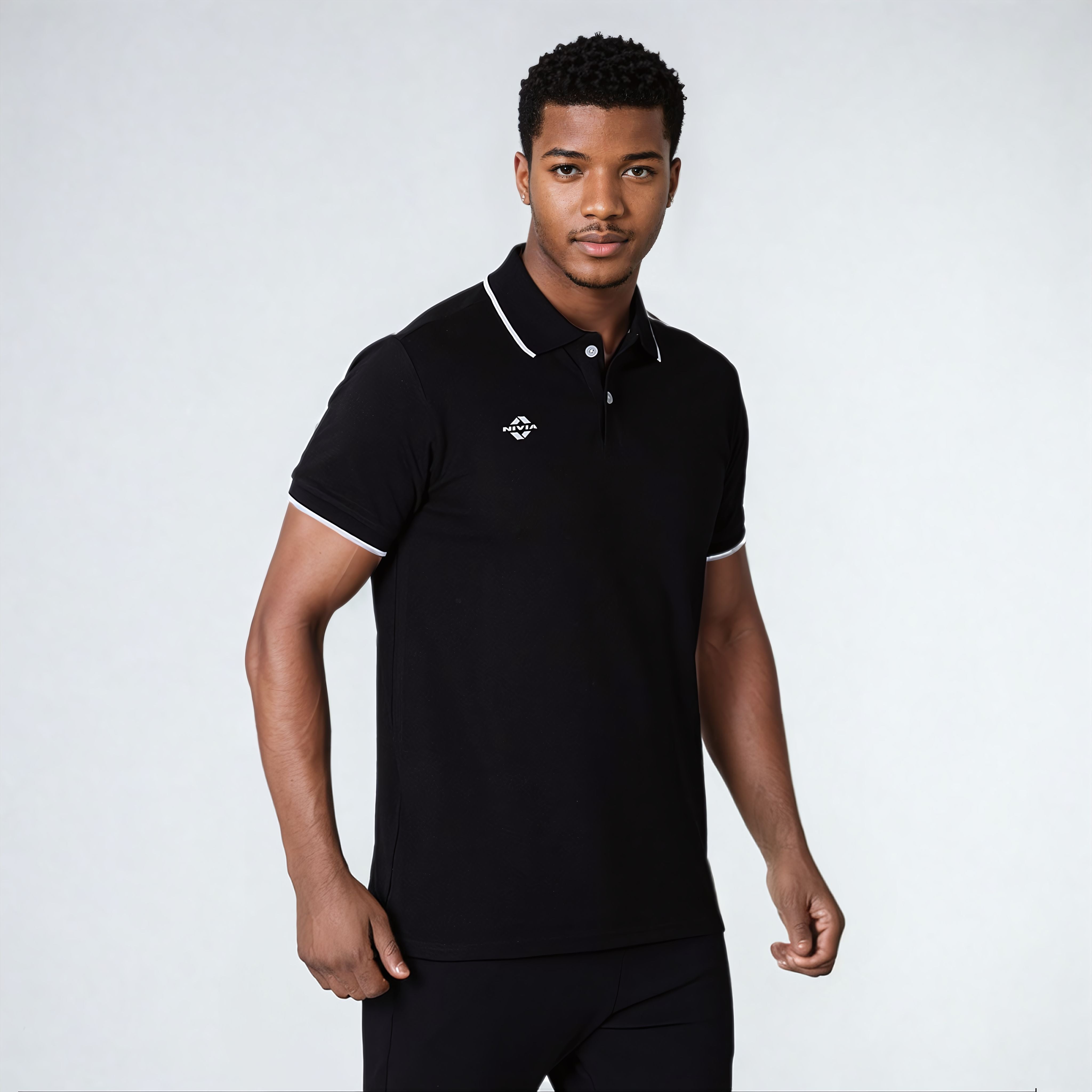 Close-up front view of a model wearing the NIVIA Ray 17 Polo Shirt in black, featuring a classic collar with button placket and contrast trim on the collar and sleeve cuffs, made from polyester cotton fabric for casual and everyday wear.