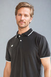 Close-up view of a model wearing the NIVIA Ray 17 Polo Shirt in black, featuring a classic collar with button placket and contrast trim on the collar and sleeve cuffs, made from polyester cotton fabric for casual wear.