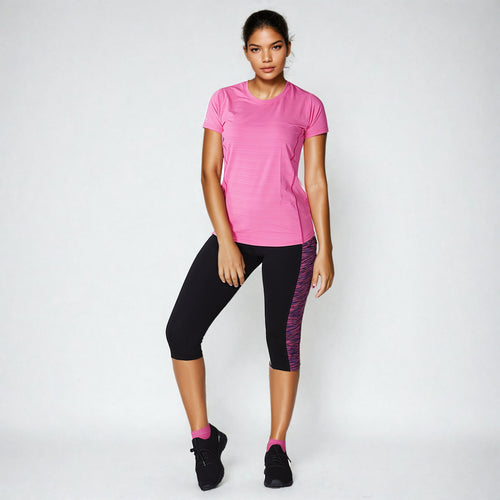 Woman wearing NIVIA Hydra 13 T-Shirt in pink performance running top paired with black leggings