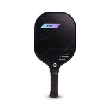 Close-up of a black Nivia K-700 pickleball paddle showing a fiberglass face with teal and purple geometric lines and a textured black handle.